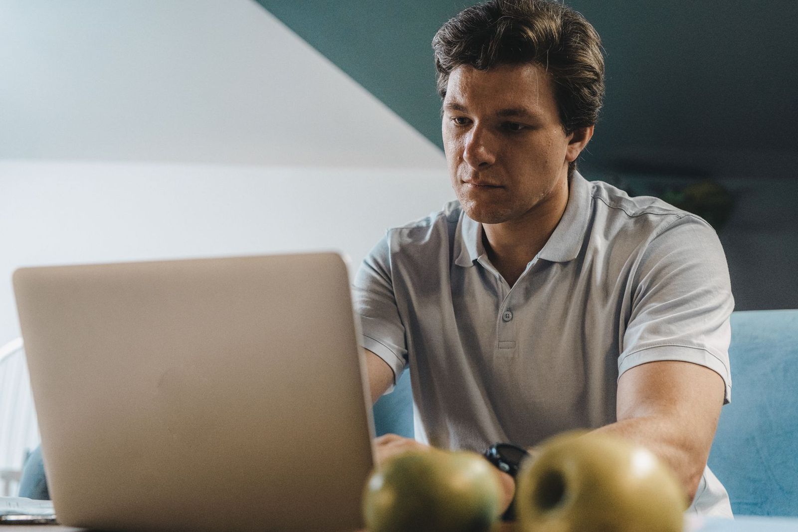 Homem jovem concentrado no notebook em ambiente interno